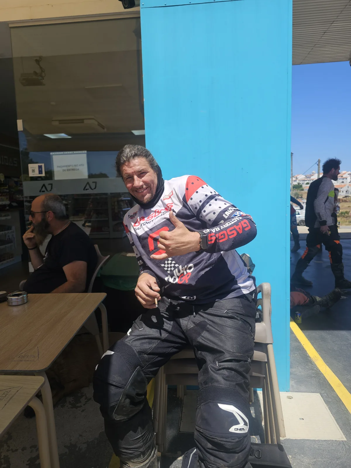 A smiling enduro rider making a shaka gesture during a riding break near Aljezur.