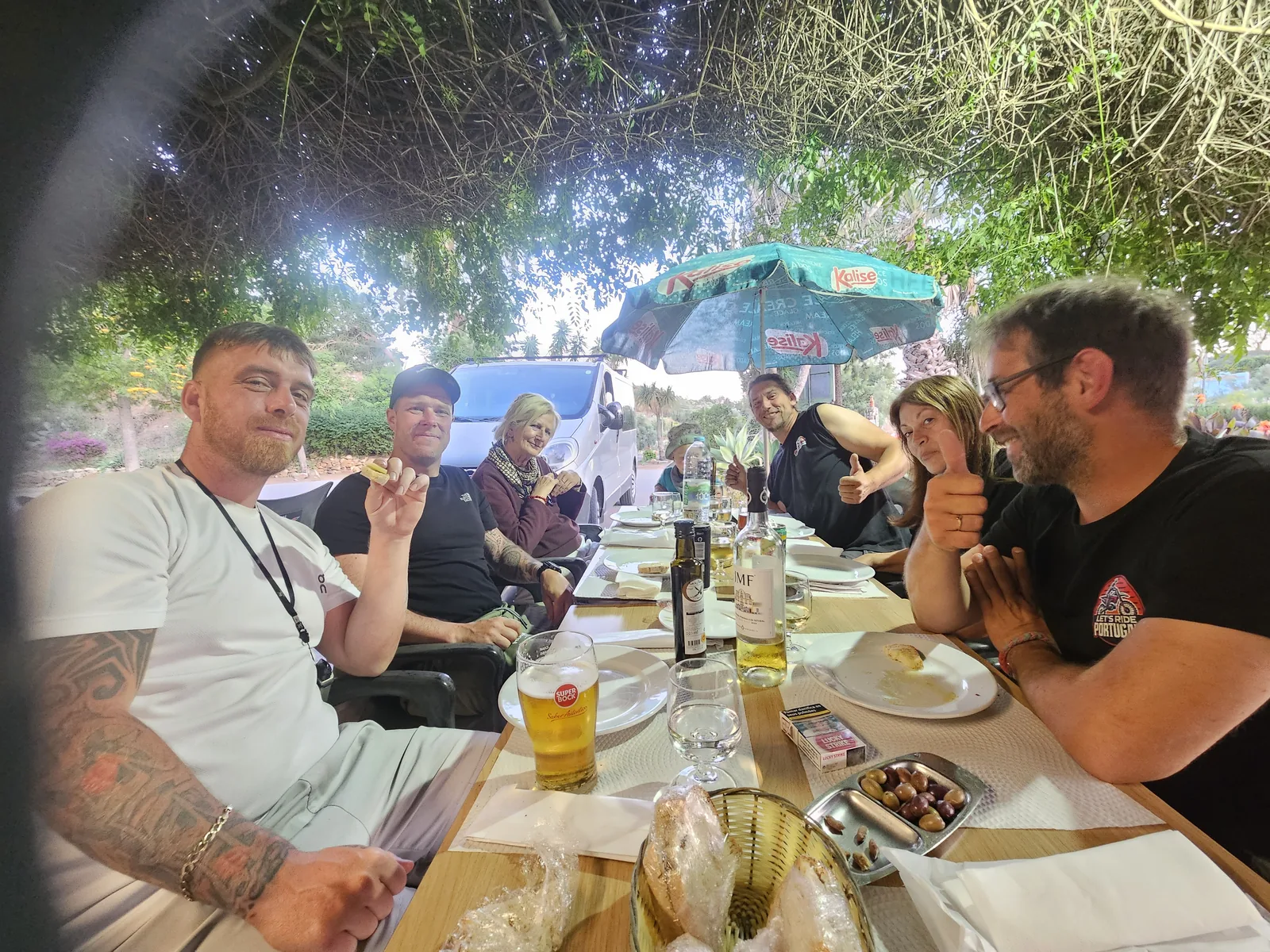 Our group sharing an outdoor meal under the greenery at Encontro d'Amigos in Rasmalho