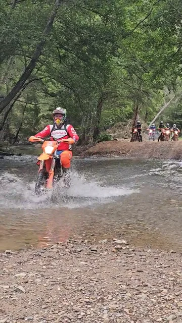 Enduro riding through a shallow stream