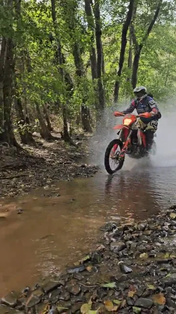 Enduro riding through a shallow stream