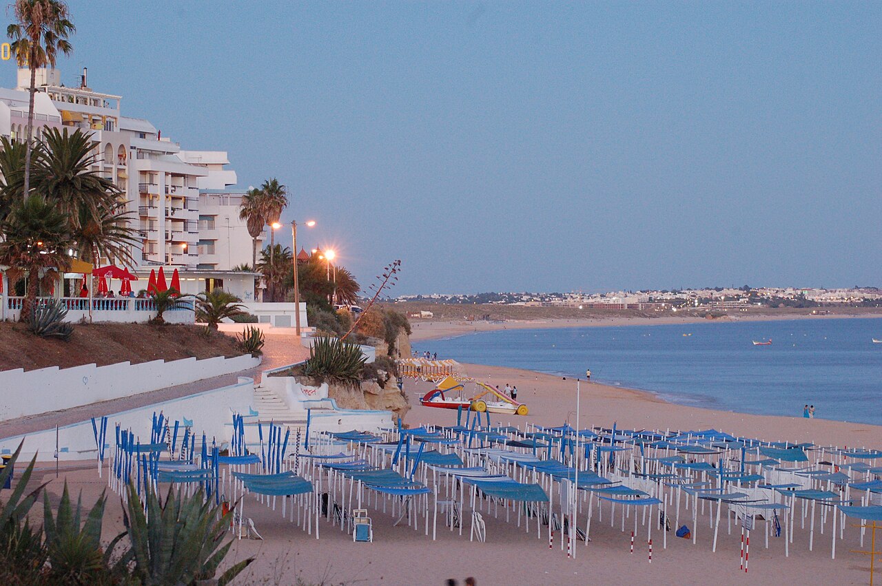 Armação de Pêra seafront and its long sandy beach at dusk.