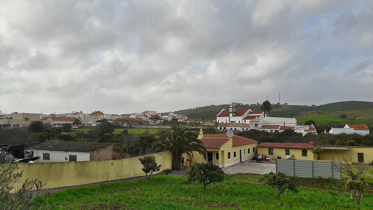 Bensafrim village and its church among fields and low hills.