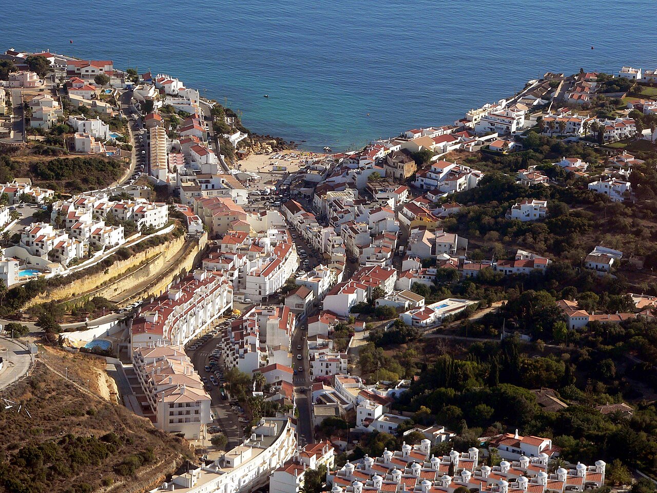 Carvoeiro houses surrounding its small beach and bay, viewed from above.