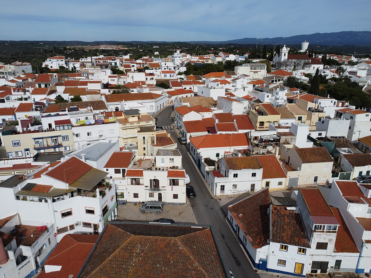 An aerial view of Mexilhoeira Grande, with white houses around the church.