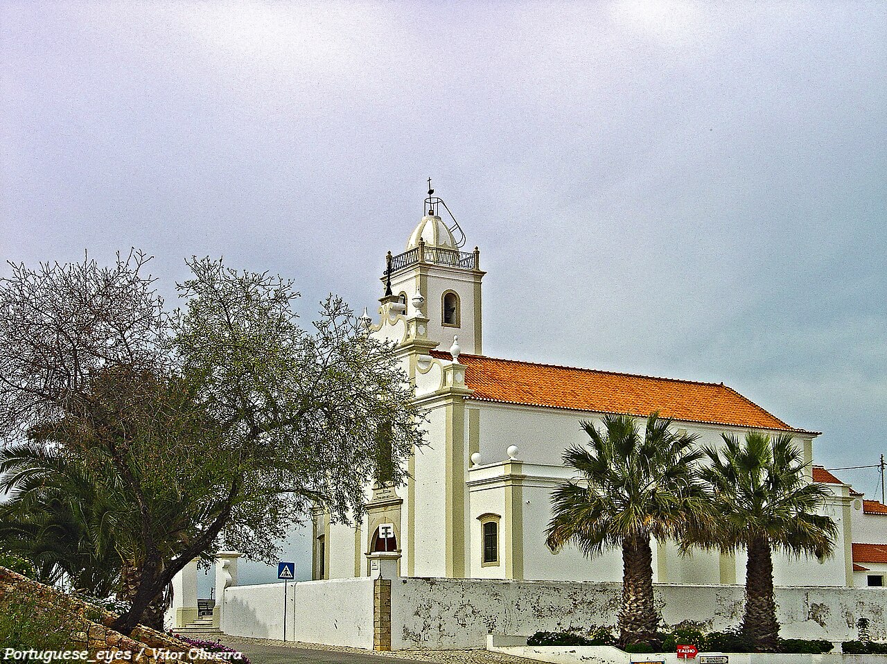 The parish church of Porches, with its bell tower and tiled roof.