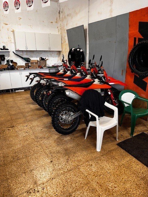 KTM enduro motorcycles lined up inside the Let's Ride Portugal workshop
