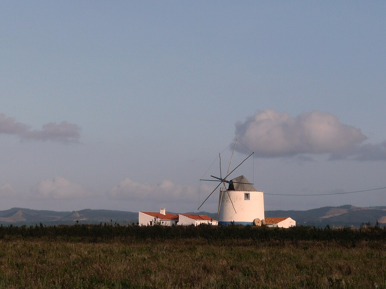 A white windmill in the open farmland around Rogil.