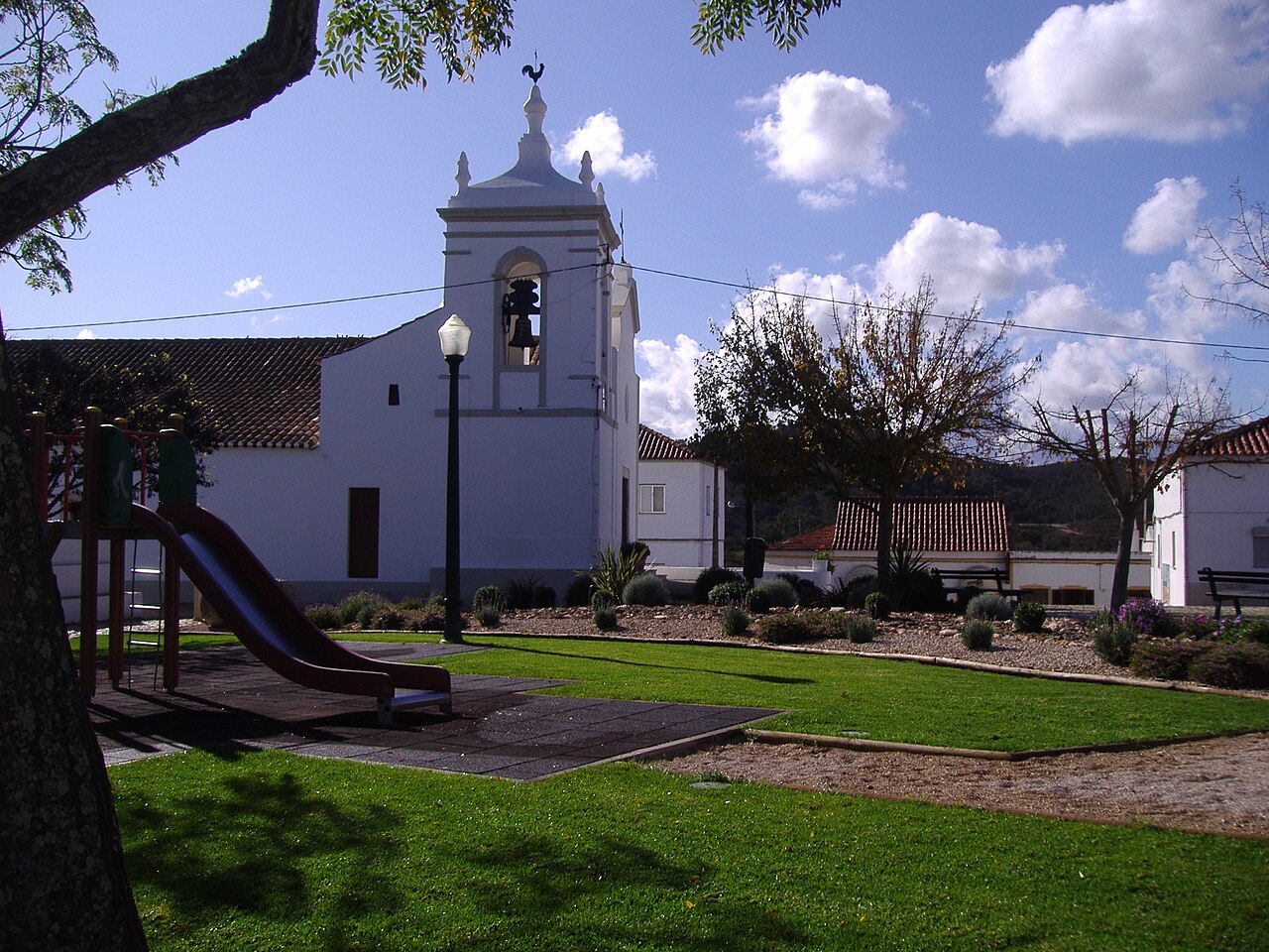 The parish church of São Marcos da Serra beside a small green square.