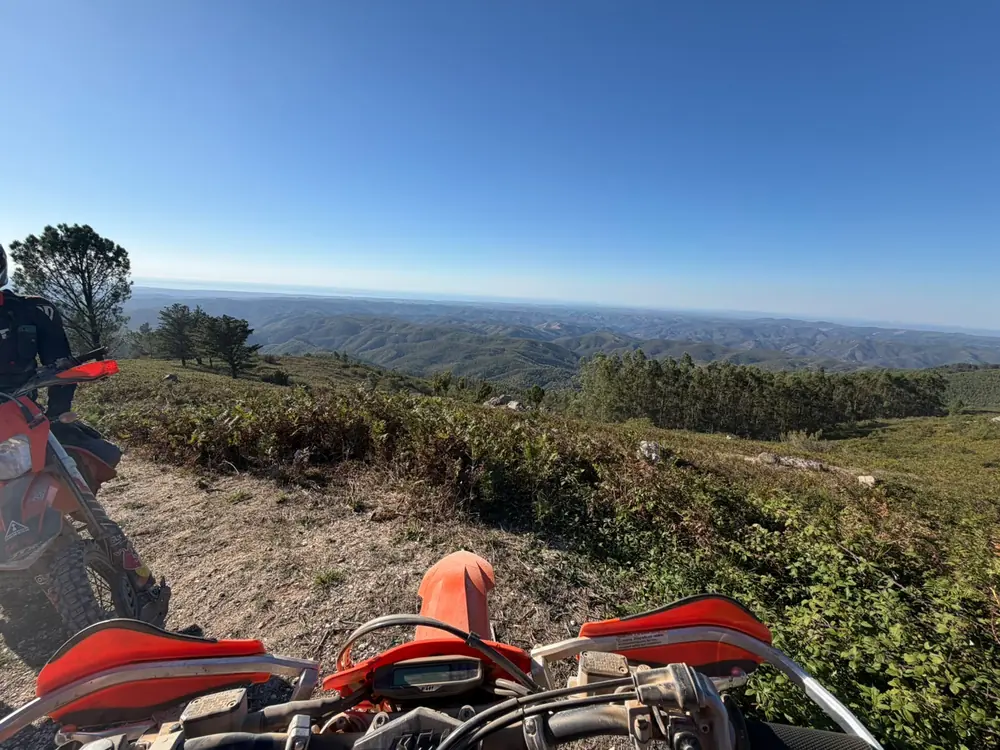View across Algarve hills and dirt trails from a KTM enduro motorcycle