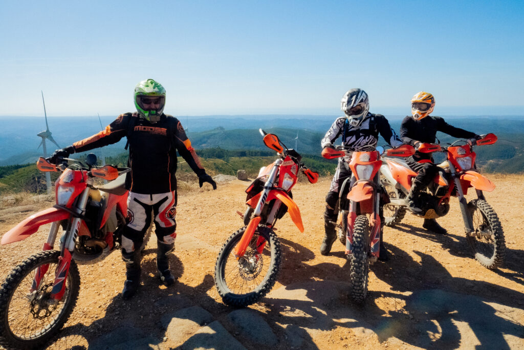Enduro riders and their motorcycles on a sunny Algarve hilltop