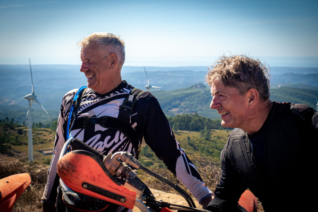 Two riders enjoying a break with their enduro motorcycles in the Algarve hills